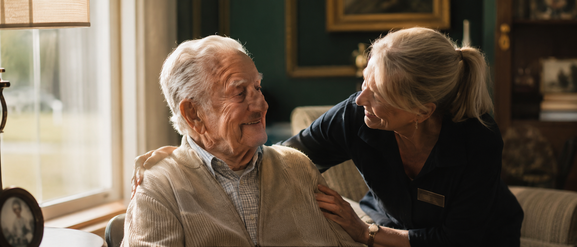 A caregiver and an older resident share a quiet, warm moment of gentle support.