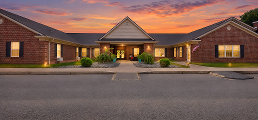 A welcoming Kentucky senior living front porch among mature trees in warm afternoon light.