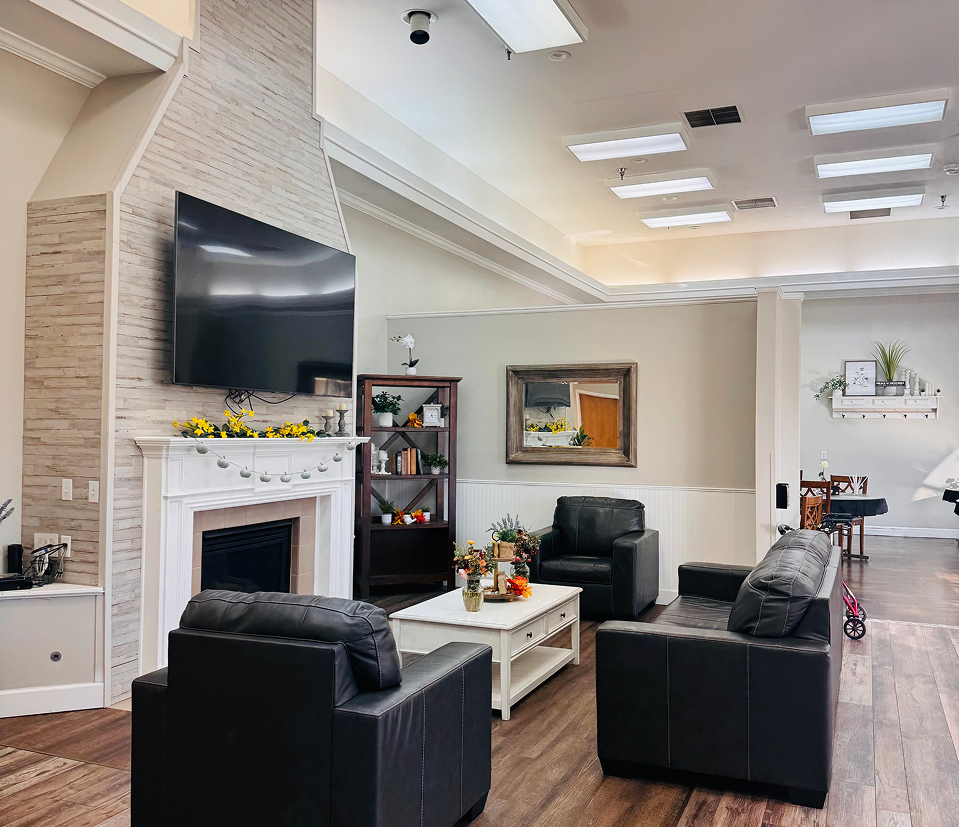 A warm community lounge with a fireplace, seating, and natural light.